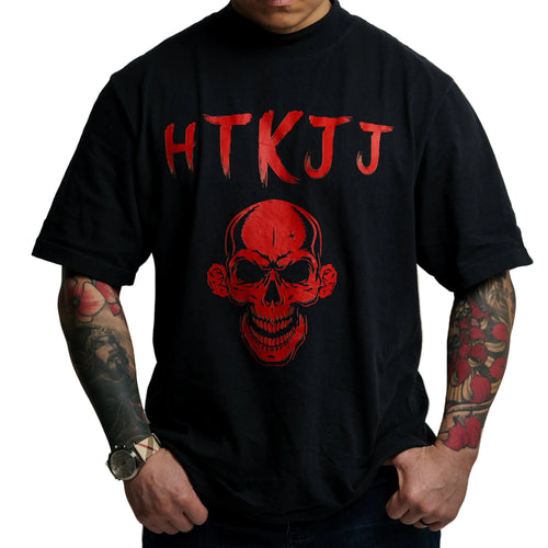 A man wearing a black t-shirt with a red graphic of a skull and the letters 'HTKJAJ' printed above it, shown from the neck down against a light gray background.